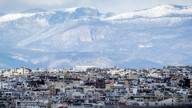 Η φωτογραφία της Ημέρας: Αθήνα και Ακρόπολη με φόντο τις χιονισμένες κορυφές της Πάρνηθας